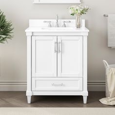 a white bathroom vanity with two sinks and a mirror over the sink, next to a potted plant