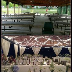 the tables are set up for an outdoor wedding with lights strung from them and flowers in vases