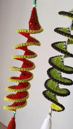 three crocheted wind chimes hanging from the ceiling in front of a white wall