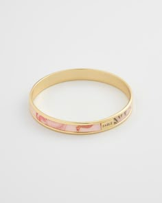 Key Features:    Nostalgic Summer Design: This gold bangle embodies the tranquility of a seaside day, adding a whimsical touch to any outfit.   High-Quality Craftsmanship: Made from 14ct gold-plated brass with an acrylic printed design in Lotus Pink for a contemporary and chic look.   Perfect Gift: Comes in a gift box with a cotton pouch, making it an ideal present for any occasion.   Dimensions:   Diameter: 2.64 inches (67 mm)  Width: 0.35 inches (9 mm)   Materials:   14ct gold-plated brass  Ac Little Gifts For Friends, Nostalgic Summer, Xoxo Jewelry, Preppy Jewelry, Cotton Pouch, Brass Bangle, Gold Plated Bangles, Jewelry Accessories Ideas, Jewelry Essentials