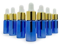 blue glass bottles with gold caps are lined up in a row on a white background