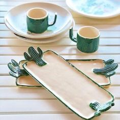 a table topped with plates and cups on top of a white tablecloth covered floor