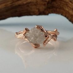 a close up of a ring with a stone in the middle on a white surface