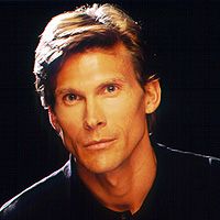 a close up of a person wearing a black shirt and looking at the camera with a serious look on his face