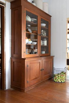 a wooden china cabinet with glass doors and shelves