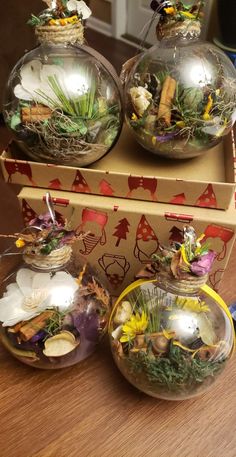 three clear glass ornaments sitting on top of a wooden table next to a cardboard box