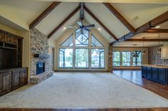 an empty living room with large windows and wood flooring is pictured in this image