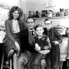 an old black and white photo of a family posing for a picture in the kitchen