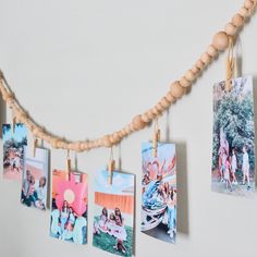 several pictures hanging from clothes pins on a string with wood beads and wooden bead