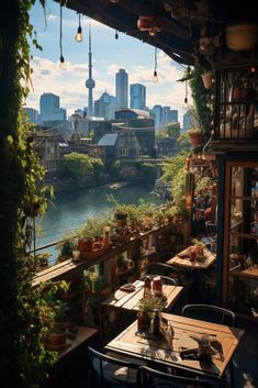 an outdoor dining area with tables and chairs overlooking the river in front of a cityscape