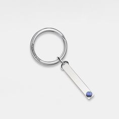 a silver keychain with a blue bead on the end and a white background