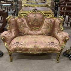 an ornately decorated couch sits in front of other antique furniture