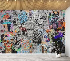 a large wall with lots of graffiti on it in an empty room next to a potted plant