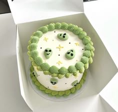 a green and white decorated cake in a box