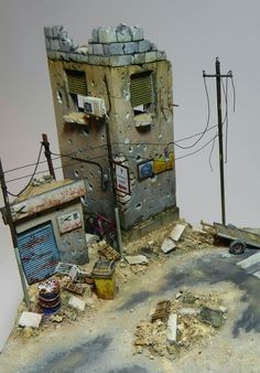 a toy model of a building with broken windows and debris on the ground in front of it