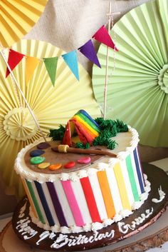 there is a colorful cake on the table with umbrellas in the backgroud