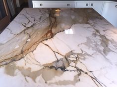 a marble counter top with white cabinets in the background