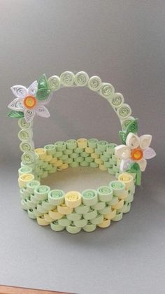 a close up of a basket made out of legos with flowers and leaves on it