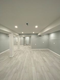 an empty room with white walls and wood floors is shown in this image, there are lights on either side of the wall