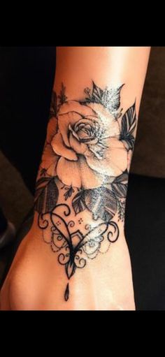 a woman's foot with a rose tattoo on it