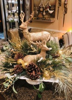 a christmas centerpiece with deer and pine cones