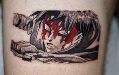 a man's leg with a red and black tattoo design on it that has an image of a demon