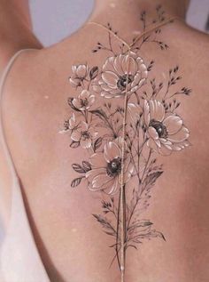 the back of a woman's body with flowers tattooed on her upper and lower back