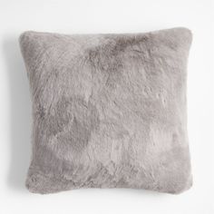 a gray pillow with fluffy fur on it