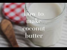 a glass jar filled with coconut butter next to a wooden spoon