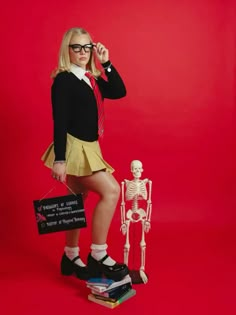 a girl in a school uniform is holding a skeleton