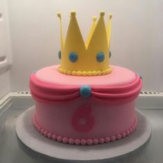 a pink cake with a yellow crown on top