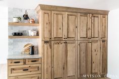 a kitchen with wooden cabinets and marble counter tops in the center, along with white walls