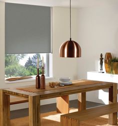 a dining room table with two benches and a lamp hanging from the ceiling over it