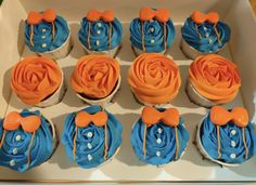 a box filled with blue and orange cupcakes