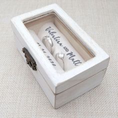 two wedding rings in a white box with writing on it