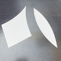 two pieces of white paper sitting on top of a metal surface