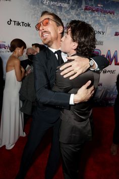 two people hugging each other on the red carpet