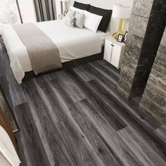 a bedroom with grey wood flooring and white bed in the corner next to a window