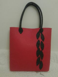 a red bag with black leaves on it