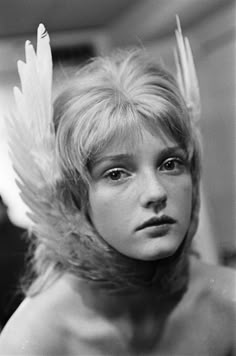 an old black and white photo of a young woman with angel wings on her head