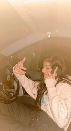 a woman sitting in a car talking on her cell phone