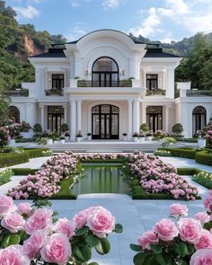 a large white house with lots of pink flowers