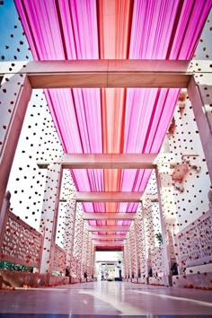 the inside of a building with pink and white curtains hanging from it's ceiling