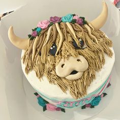 a cake decorated to look like a bull's head with flowers around it and eyes