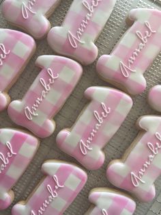 pink and white decorated cookies with names on them