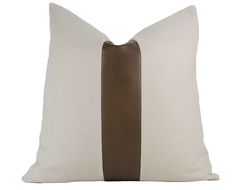 a brown and white pillow with two contrasting stripes on the front, along with a tan stripe down the middle