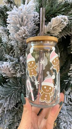 a hand holding up a glass jar with gingerbreads on it