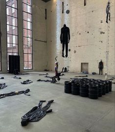 an empty room filled with lots of black tires and other items on the floor in front of large windows