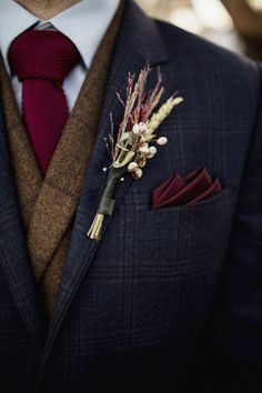 a man wearing a suit and tie with a boutonniere on his lapel