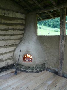 a wood burning stove in a room with wooden flooring and walls that have been made out of logs